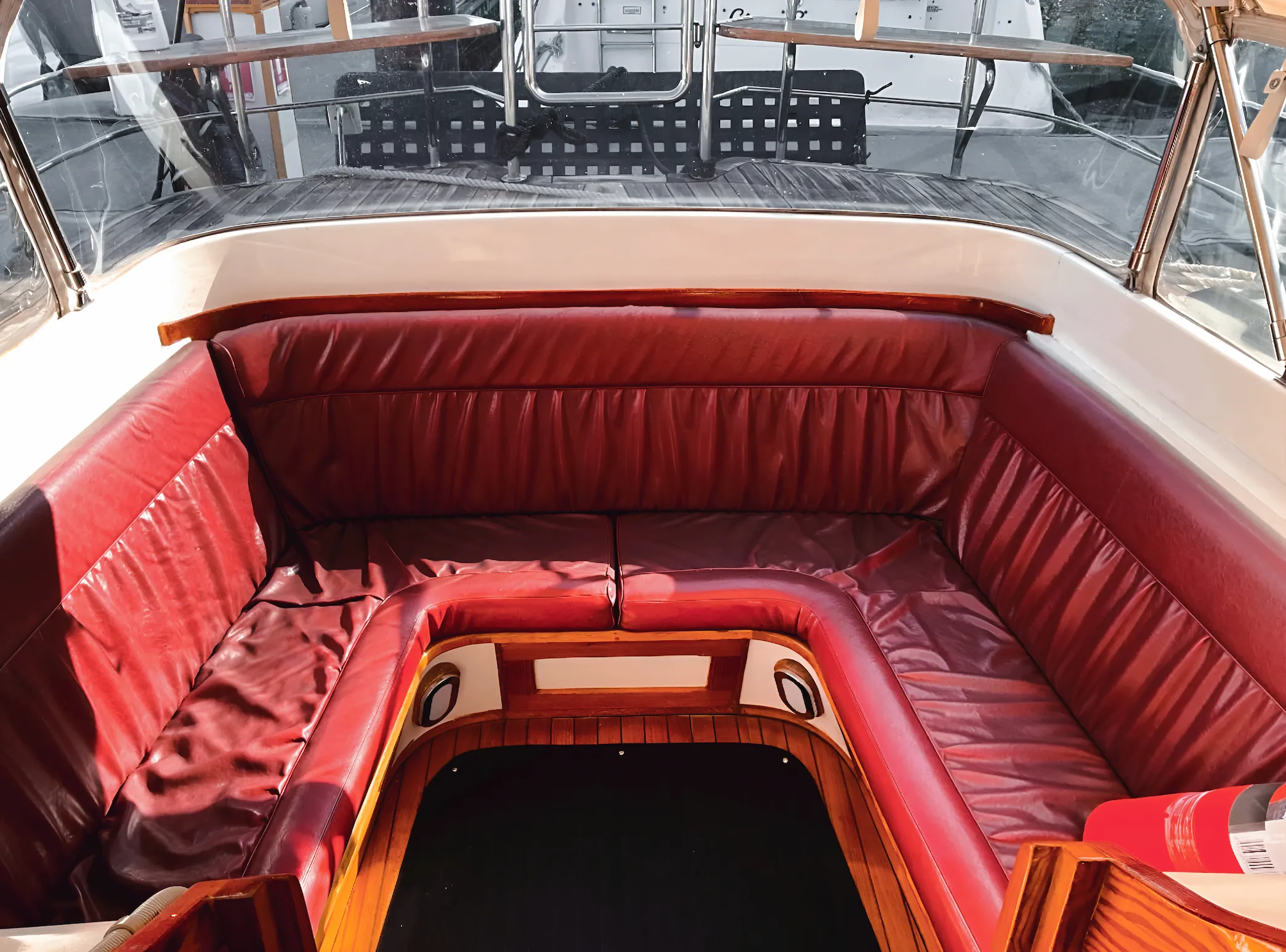 The open stern cockpit with wraparound red leather bench seating, polished and ready